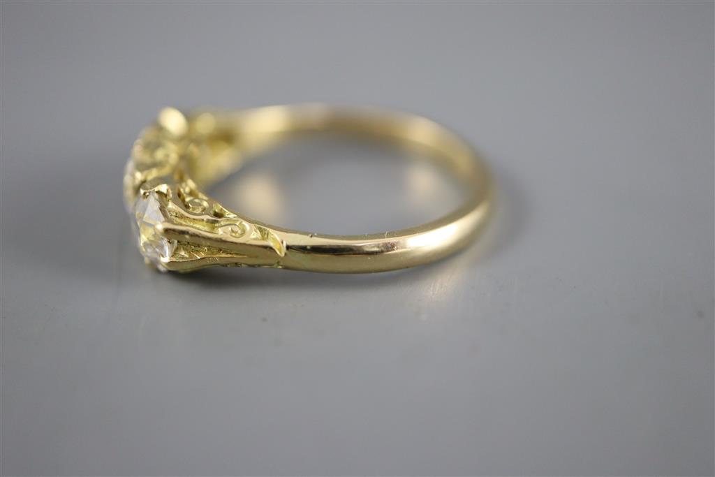 A Victorian style yellow metal and three stone diamond ring with diamond chip spacers, size Q, gross 4.5 grams.